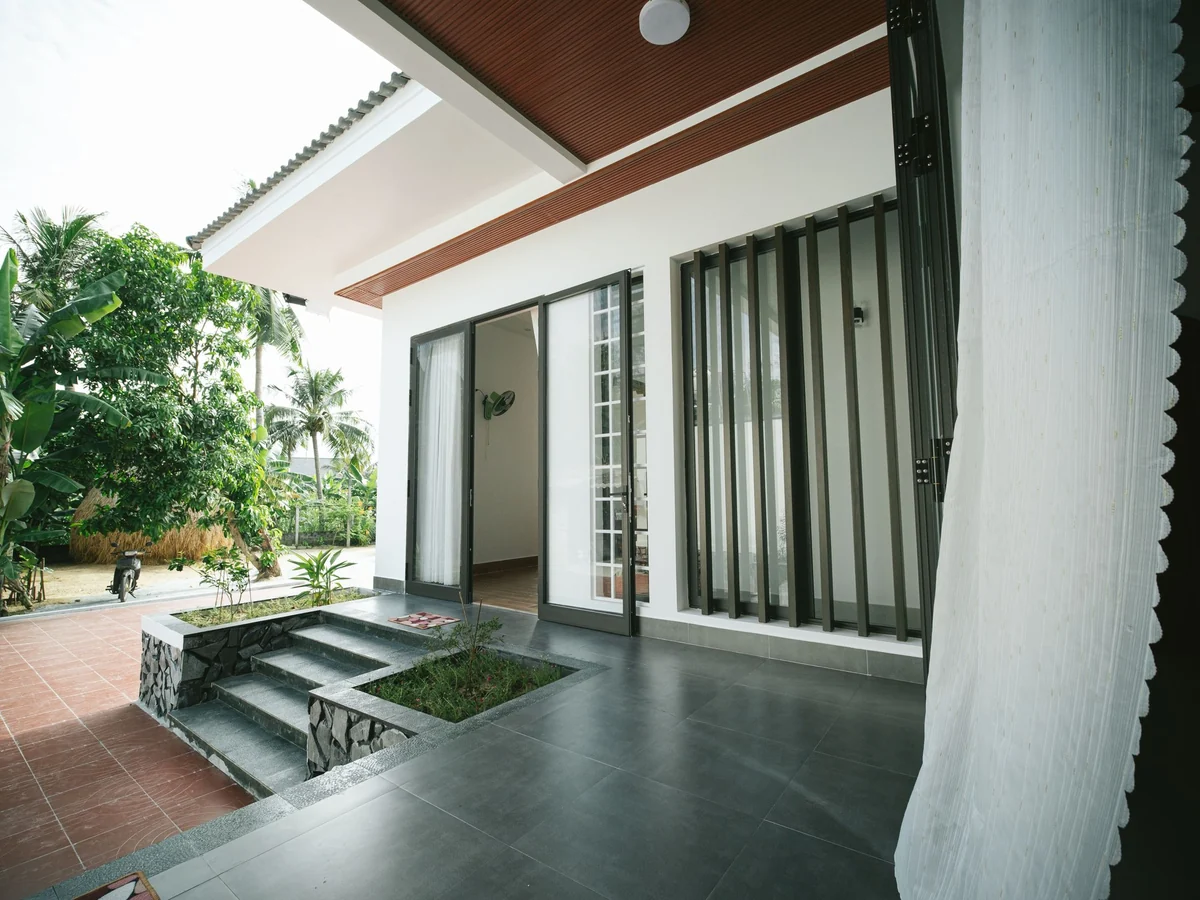 Single-storey house opening onto a paved patio and garden