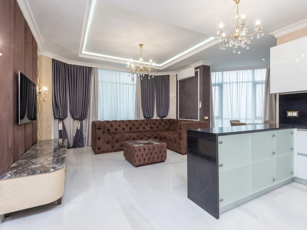 Spacious living room with chandeliers and a plush sofa